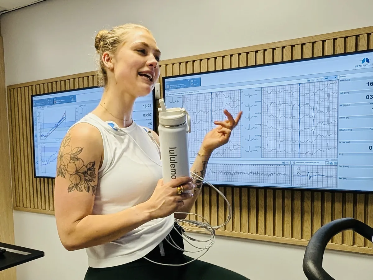 Charlotte Weidenbach on the exercise bike during her heart and lung exercise test, her live ECG on the screens behind her