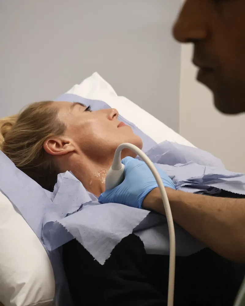 A vascular scientist scanning the arteries in a client's neck with ultrasound